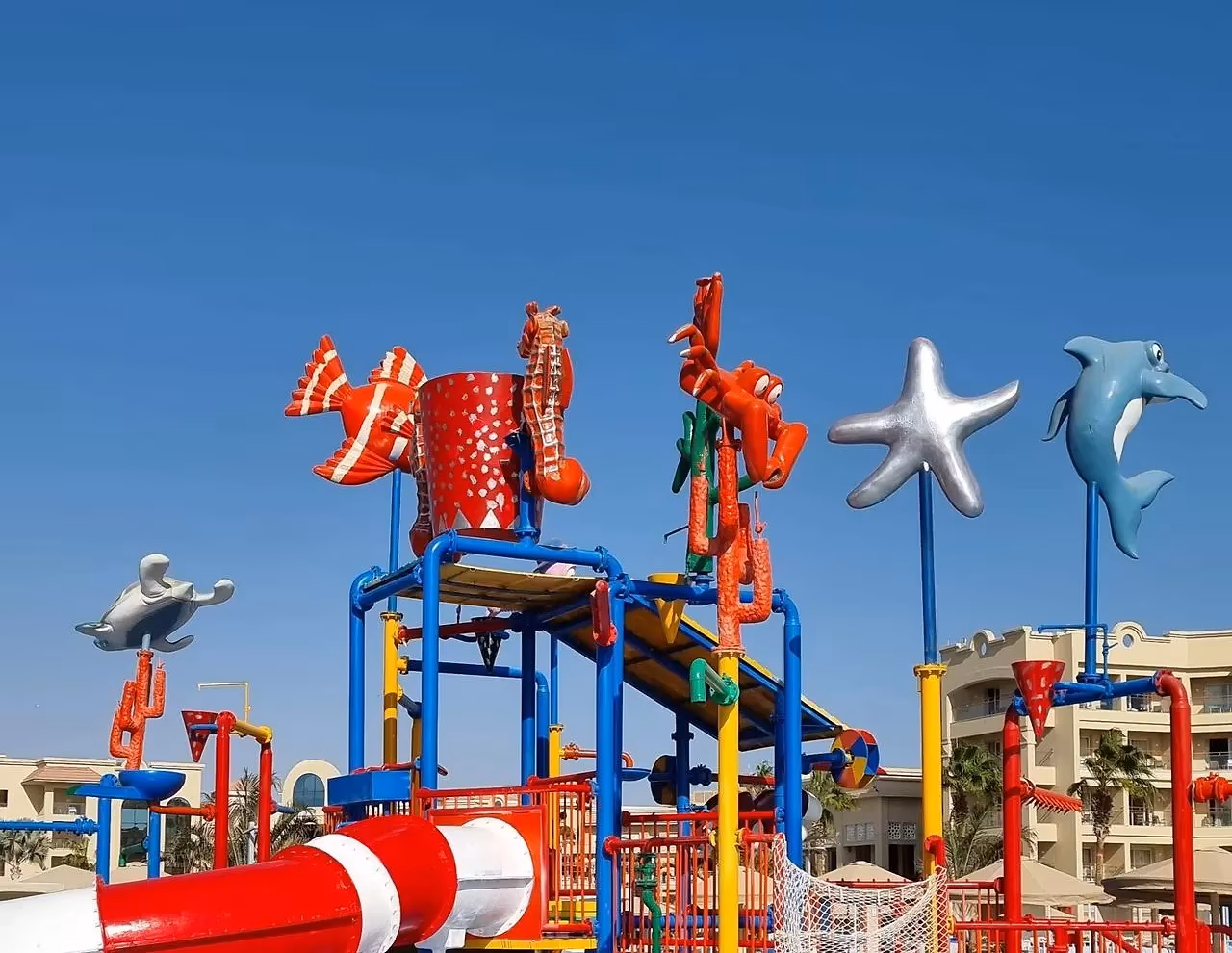 Speelstructuur met een glijbaan en gekleurde zeedieren in een kinderbad van een waterpark