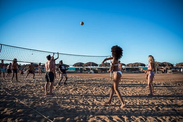 Beachvolleybal op het zandstrand met rieten parasols, SUNRISE Crystal Bay Resort in Hurghada