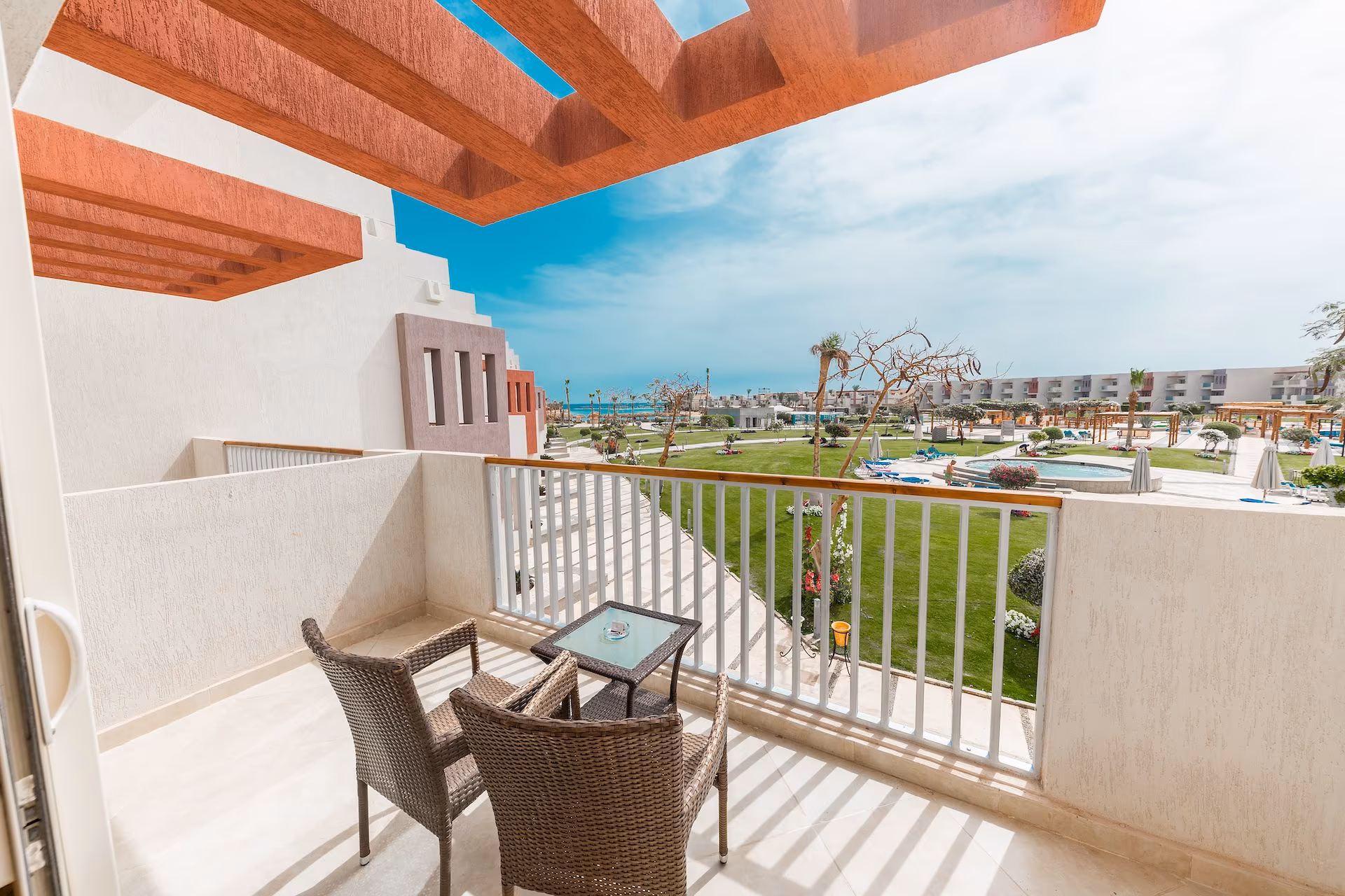 Balkon van de Deluxe Room met zicht op tuin, zwembad en zee, SUNRISE Crystal Bay Resort in Hurghada