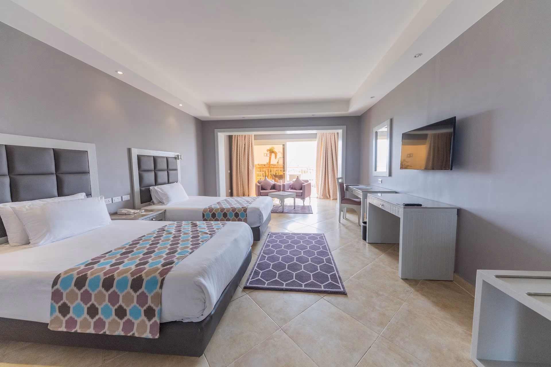Deluxe Room met twee grote bedden en zithoek bij het balkon, SUNRISE Crystal Bay Resort in Hurghada