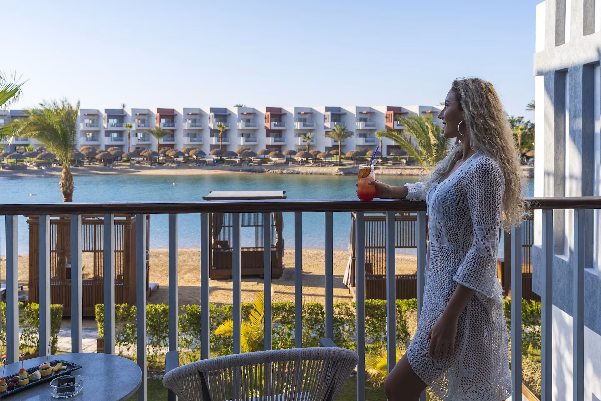 Balkon van de Jacuzzi Suite met zicht op de lagune, gast met drankje, SUNRISE Crystal Bay Resort in Hurghada