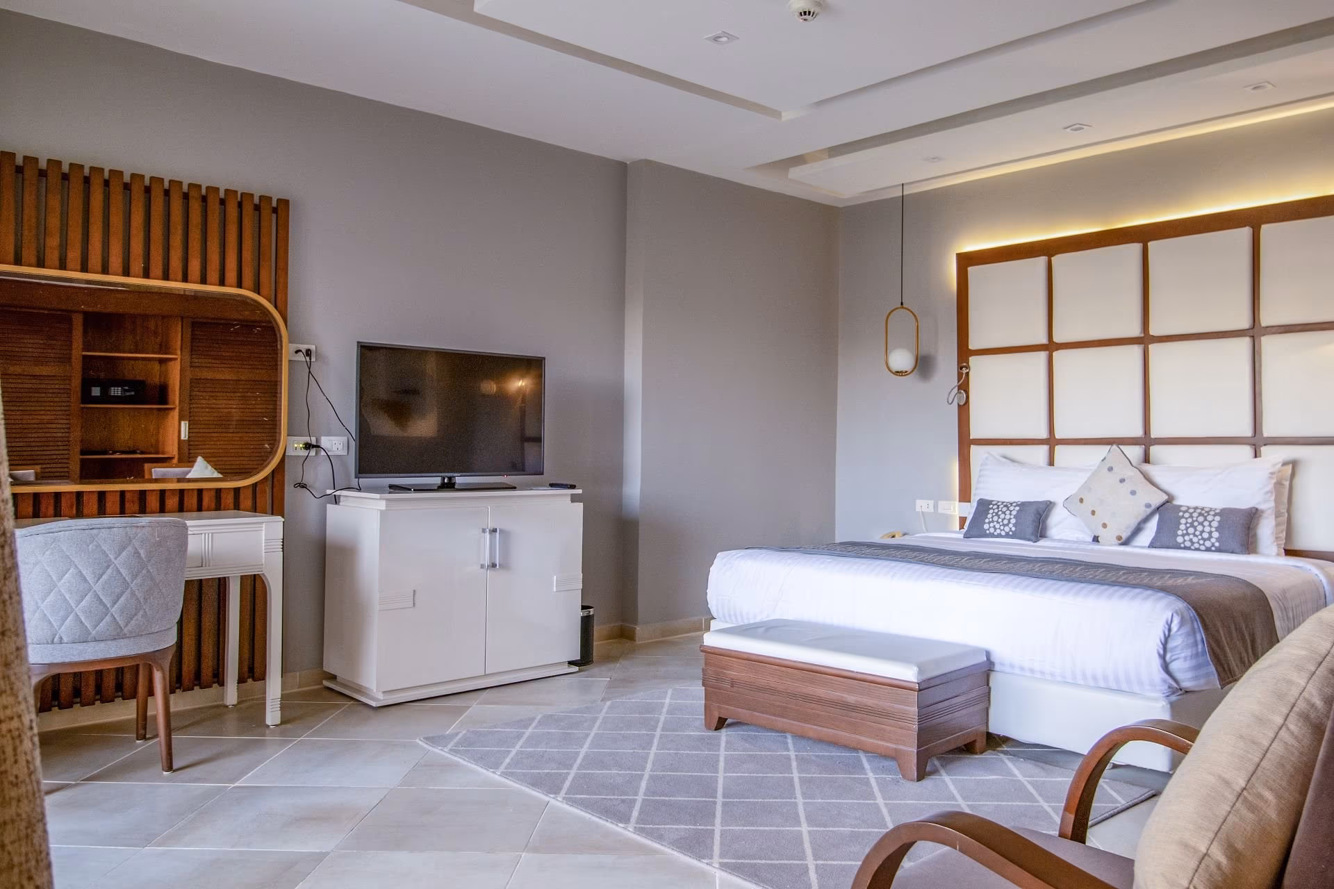 Slaapkamer van de Junior Swim-Up Suite met tv-meubel, SUNRISE Crystal Bay Resort in Hurghada