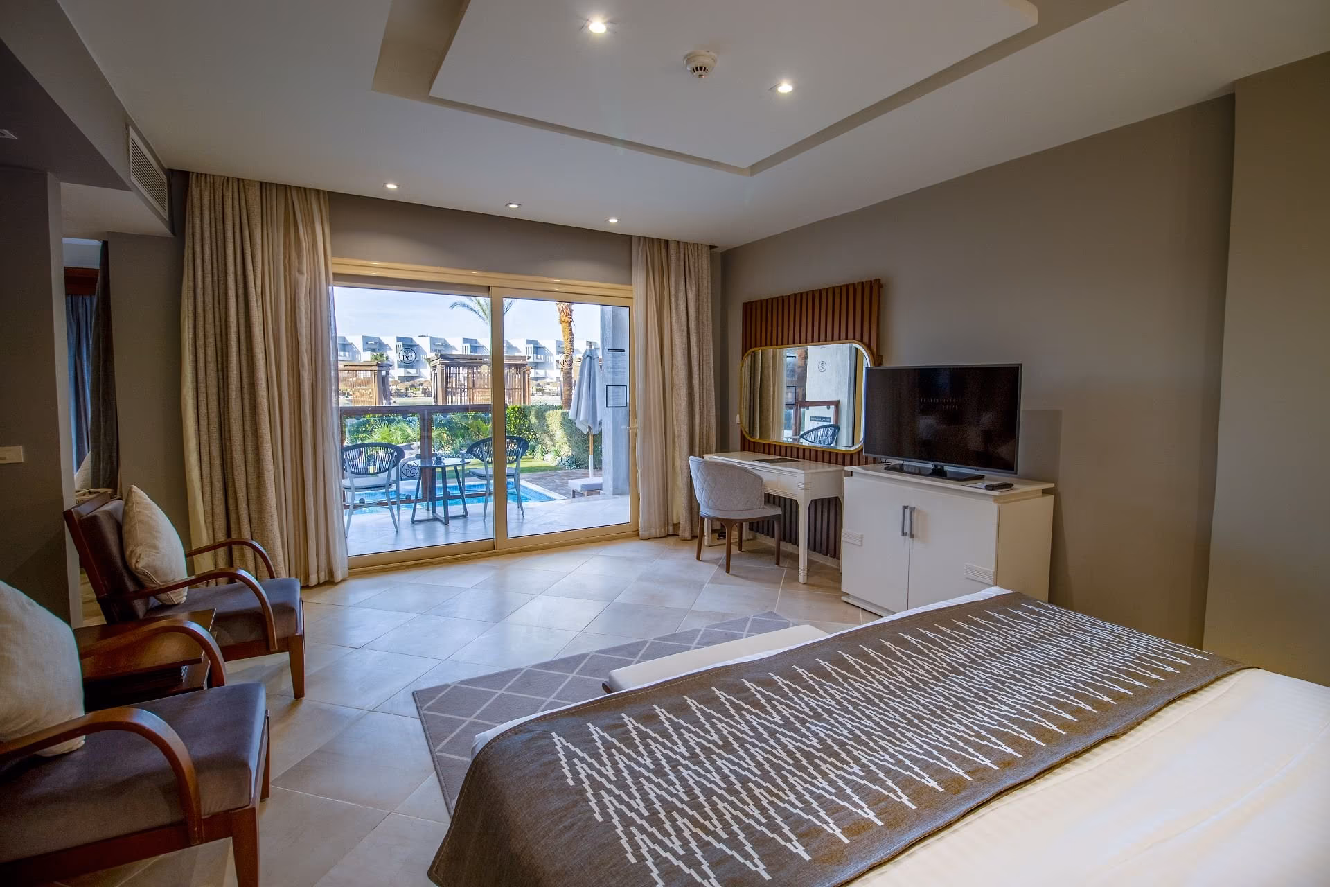 Slaapkamer van de Junior Swim-Up Suite met zicht op terras en zwembad, SUNRISE Crystal Bay Resort in Hurghada
