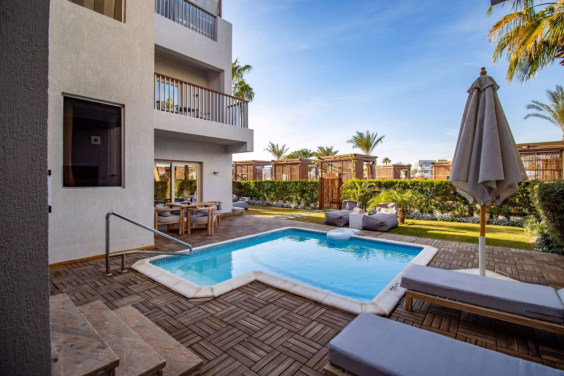 Zwembad en terras aan de Junior Swim-Up Suite met ligbedden en parasol, SUNRISE Crystal Bay Resort in Hurghada