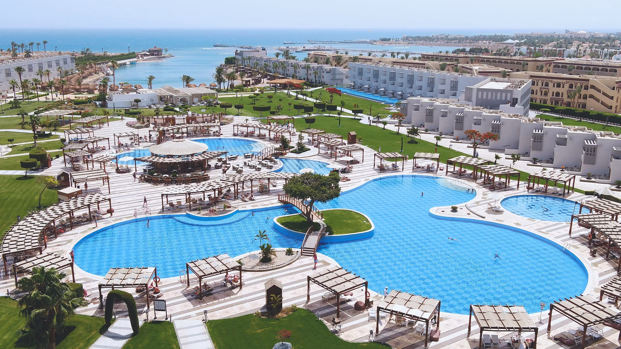 Luchtfoto over de zwembaden, de tuin, de laagbouw en de lagune aan zee, SUNRISE Crystal Bay Resort in Hurghada