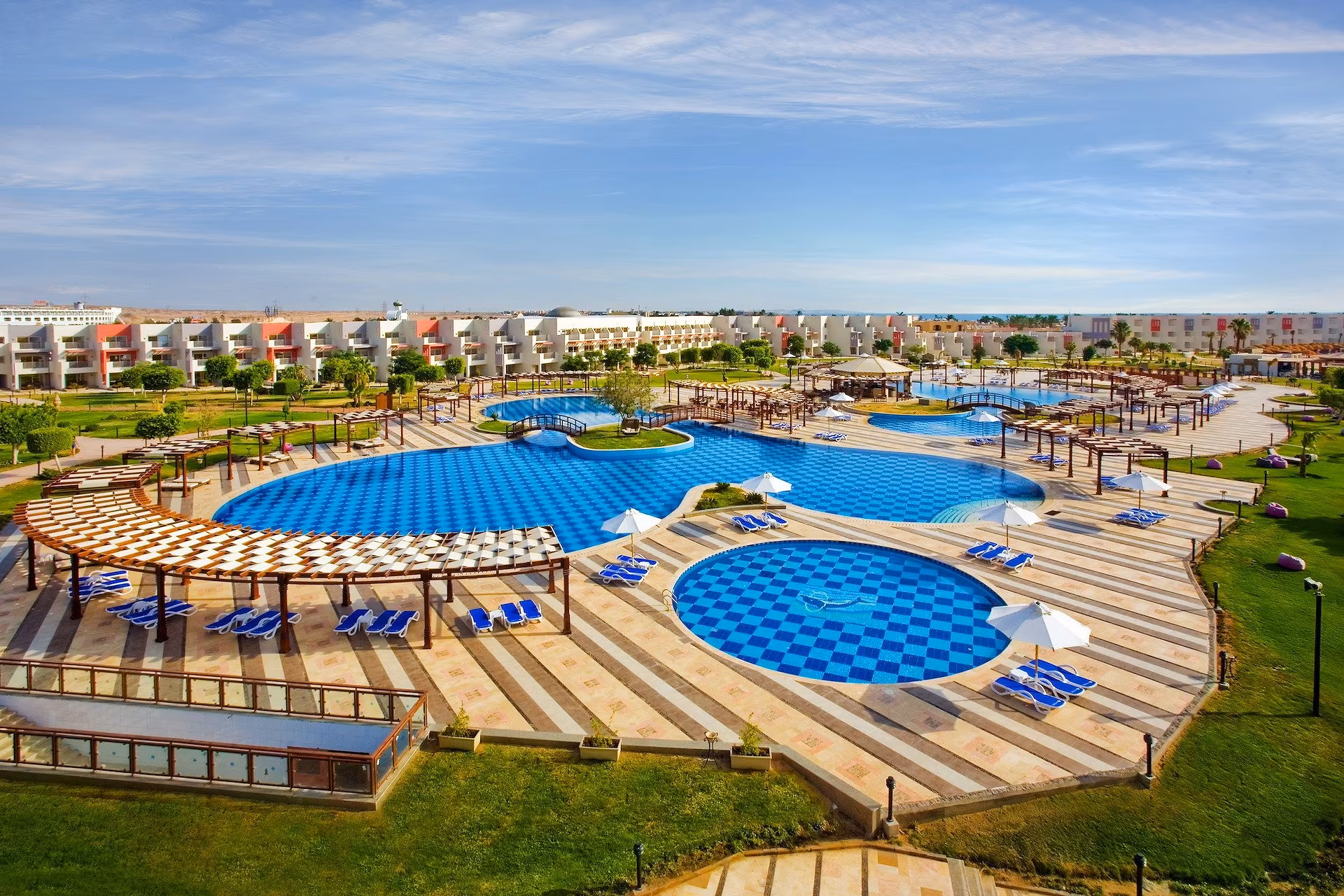 Luchtfoto over de zwembaden met strandinstap, de pergola's en de laagbouw van SUNRISE Crystal Bay Resort in Hurghada