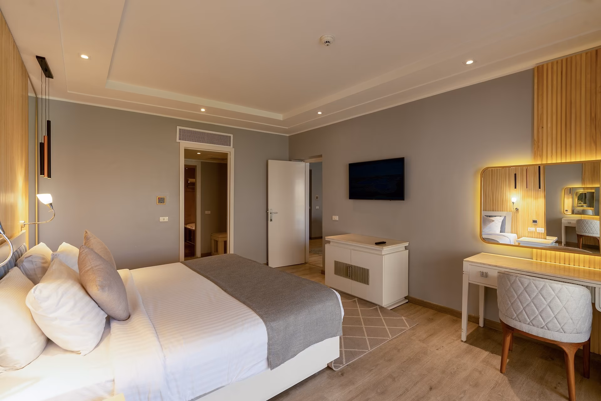 Slaapkamer van de Royal Suite met kingsize bed en verlichte kaptafel, SUNRISE Crystal Bay Resort in Hurghada