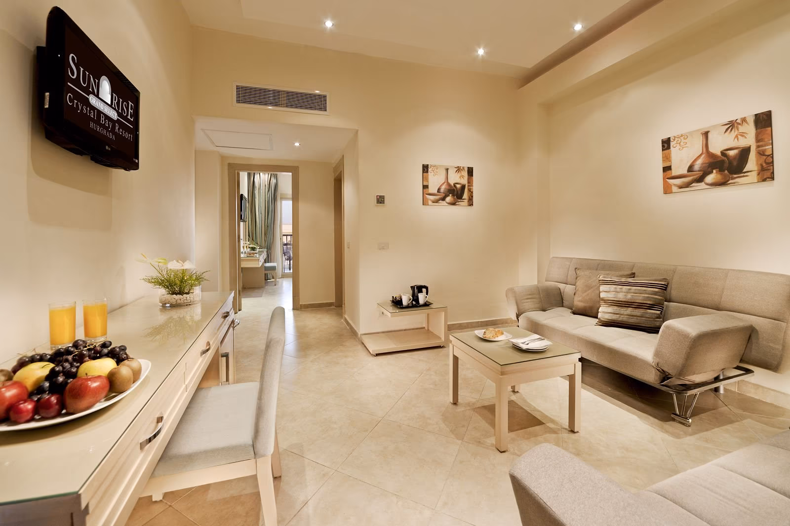 Woonkamer met bank, salontafel en fruitschaal in een suite, SUNRISE Crystal Bay Resort in Hurghada
