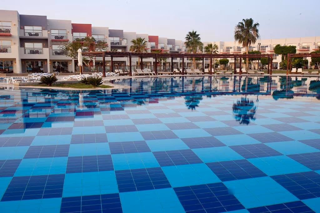 Zwembad met geblokte bodem en weerspiegeling van de kamers, SUNRISE Crystal Bay Resort in Hurghada