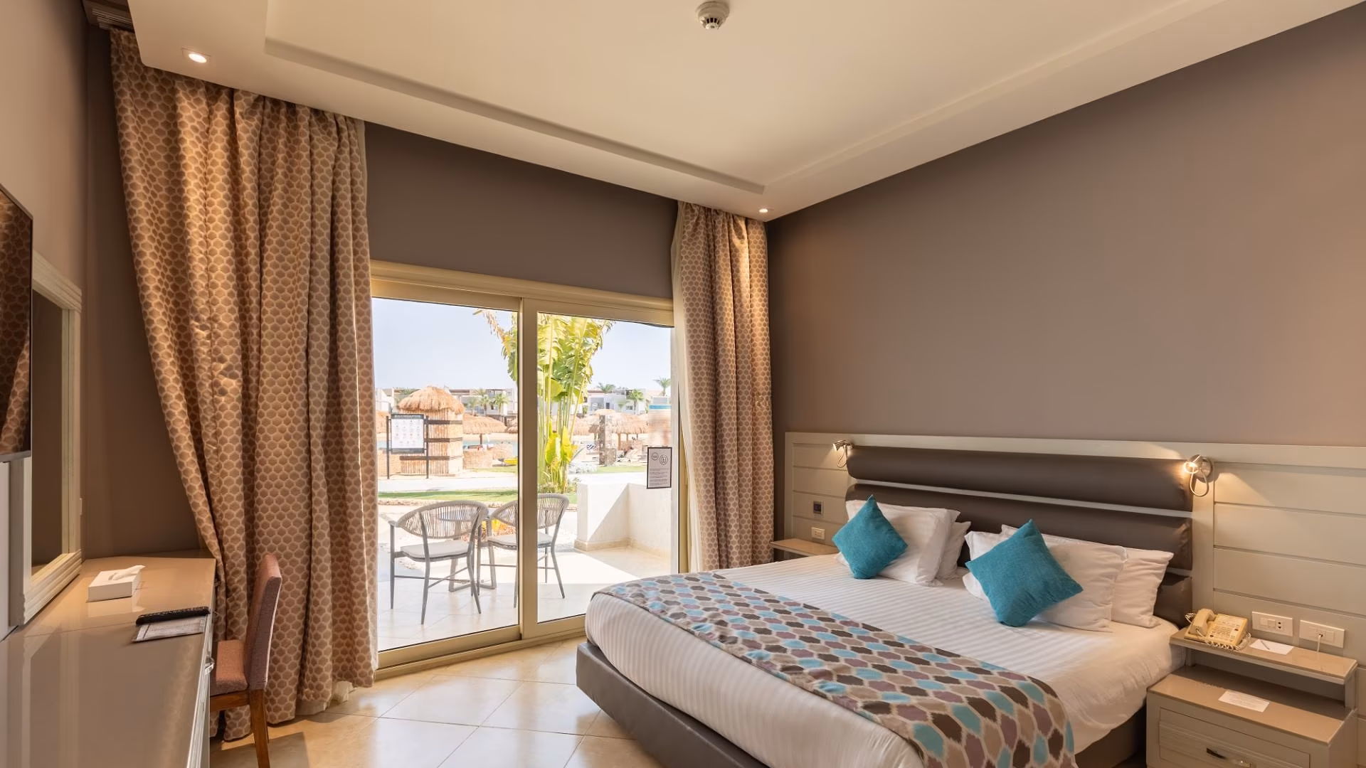 Kamer met kingsize bed en balkon met zitje, SUNRISE Crystal Bay Resort in Hurghada