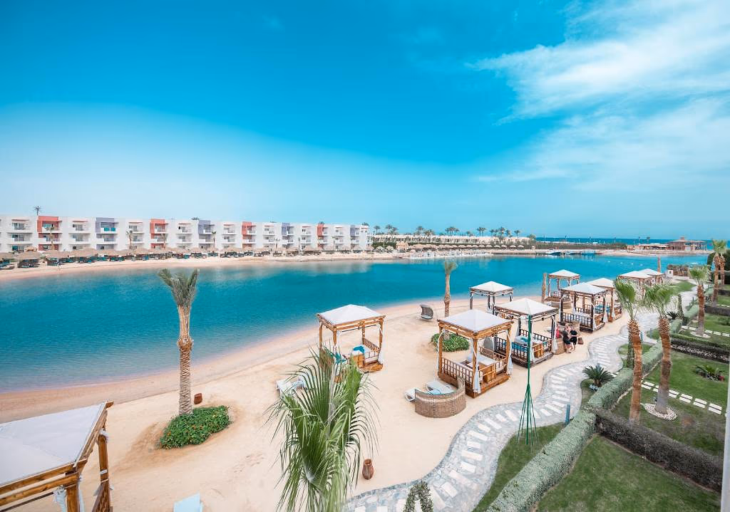 Het zandstrand aan de lagune met cabana's en palmen, SUNRISE Crystal Bay Resort in Hurghada