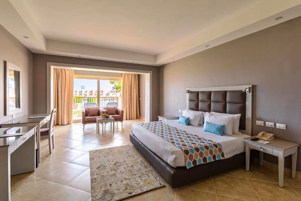Kamer met kingsize bed, vloerkleed en balkon, SUNRISE Crystal Bay Resort in Hurghada