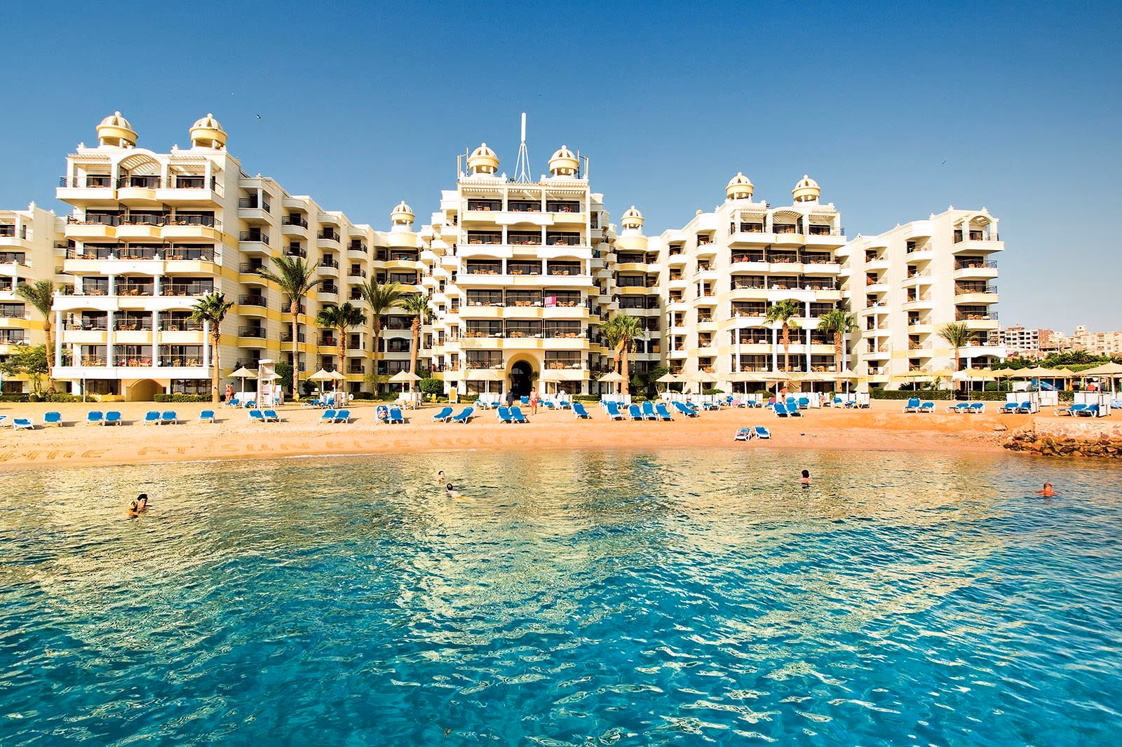 Sunrise Holidays Resort: hoge witte gevels boven een zandbaai vol blauwe ligbedden